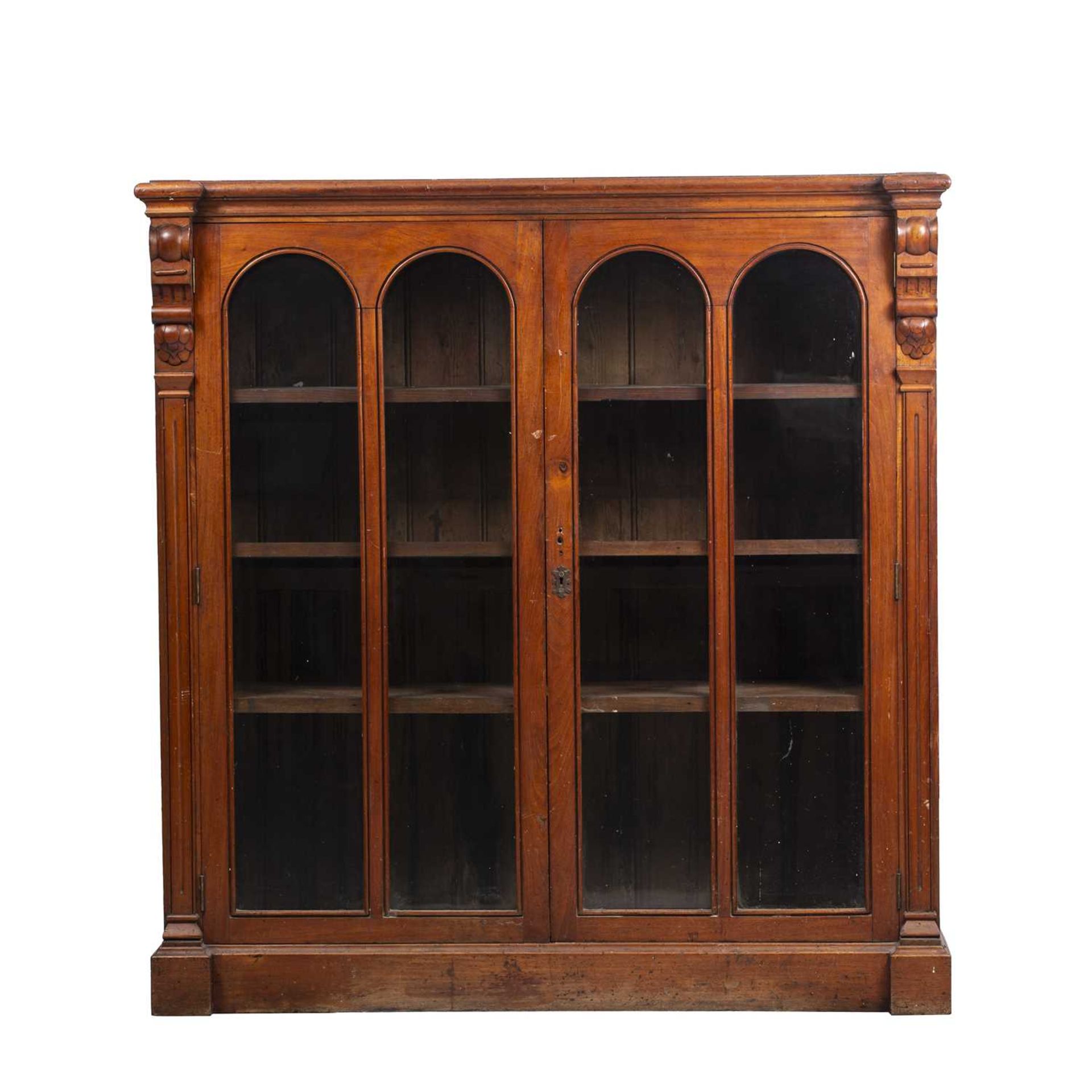 A Victorian mahogany bookcase with twin glazed doors and a plinth base 117cm wide x 38cm deep x