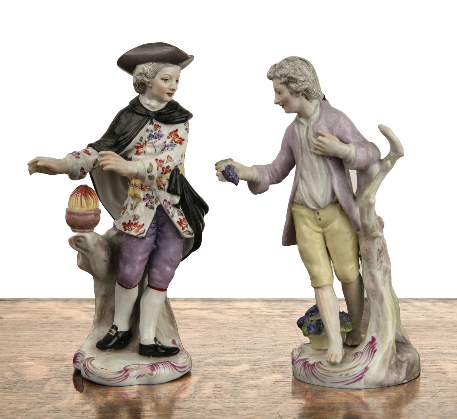 Pair of Continental porcelain figures one of a gentleman wearing a floral waistcoat, the other