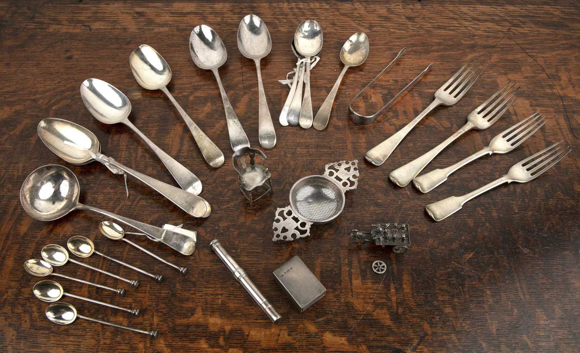 Collection of silver including: large silver serving spoons, forks, teaspoons, tea strainer, sugar