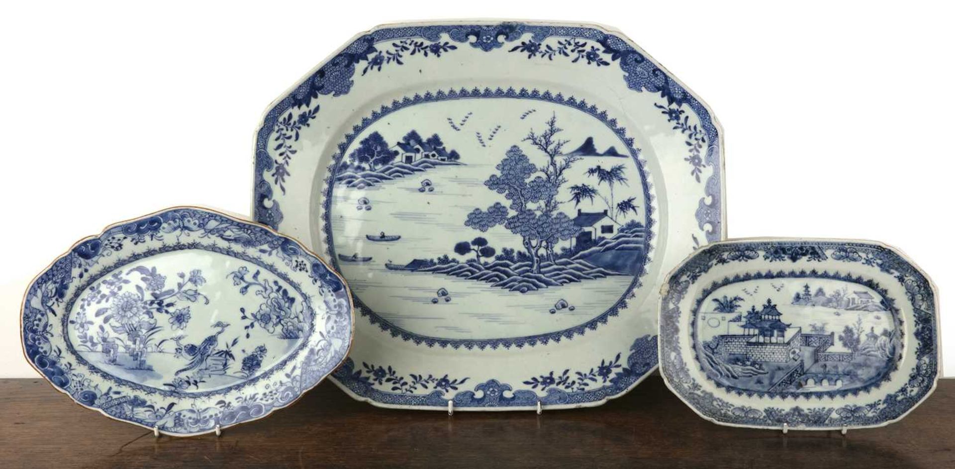 Three blue and white export dishes Chinese, circa 1800, the largest meat plate with tree and