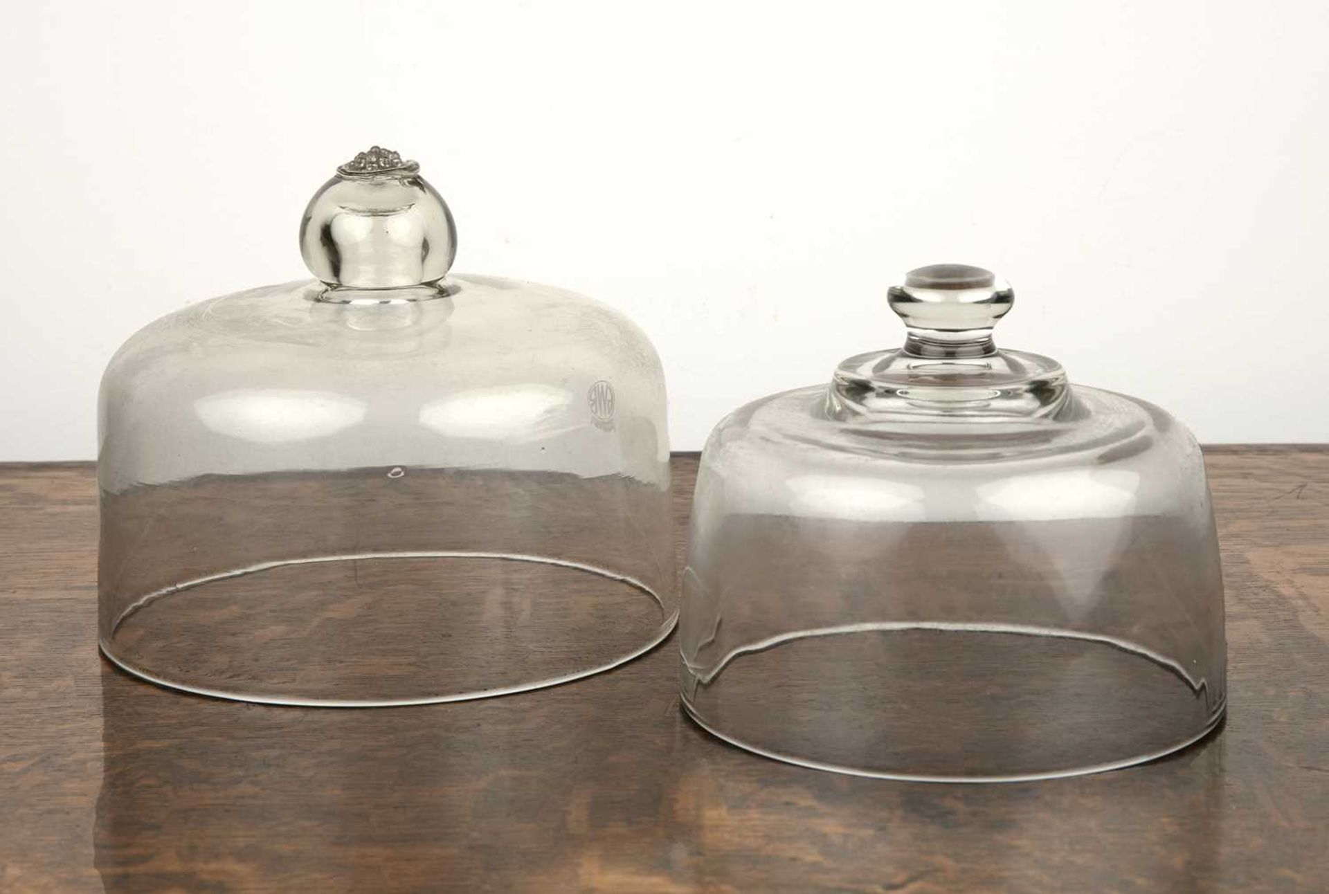Two GWR glass food covers each with a knop handle, 19.5cm and 16.5cm diameter, the larger dome is