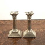 Pair of Corinthian column silver candlesticks on stepped square plinths, with loaded bases,