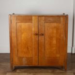 Heals cupboard Oak, design number '348', with two panelled doors enclosing shelves, raised on square
