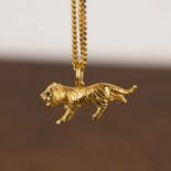 Continental precious yellow metal pendant In the form of a tiger, with facet cut green eyes on a