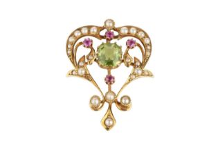 An early 20th century vari gem-set brooch/pendant, the openwork scrolled cartouche centred with an