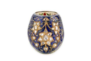 An Indian enamel and diamond set archer's ring, the shaped mount applied with a trio of flowerhead