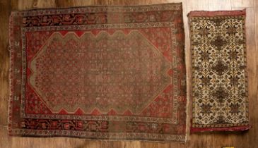 Red ground rug with a shaped central panel, approximately 141.5cm long x 108cm wide, together with