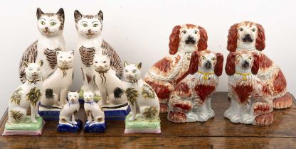 Group of Staffordshire pottery cats and dogs to include a pair of tabby cats, seated on mint green