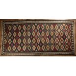 Kelim dark ground rug with diamond shaped designs, 280cm x 140cm Some overall wear.