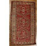 Caucasian red ground rug with three central medallions, with a geometric design and animal