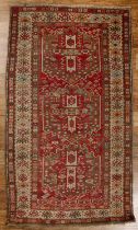 Caucasian red ground rug with three central medallions, with a geometric design and animal