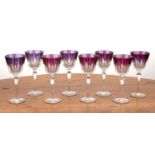Set of eight flashed and cut glass drinking glasses with facet cut bowls on faceted tapering stem,