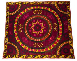 Crimson ground suzani Uzbekistan, with a central star design, and radiating stylised foliate