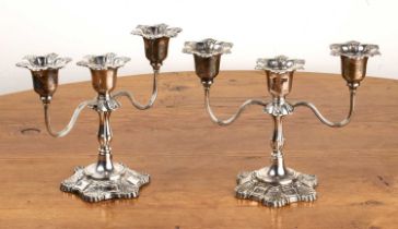 Pair of silver candelabrum in classical style, each with three branches and with shell decoration,