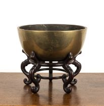 Heavy bronze bowl on a hardwood stand Chinese, 19th Century of plain form with a double dragon and
