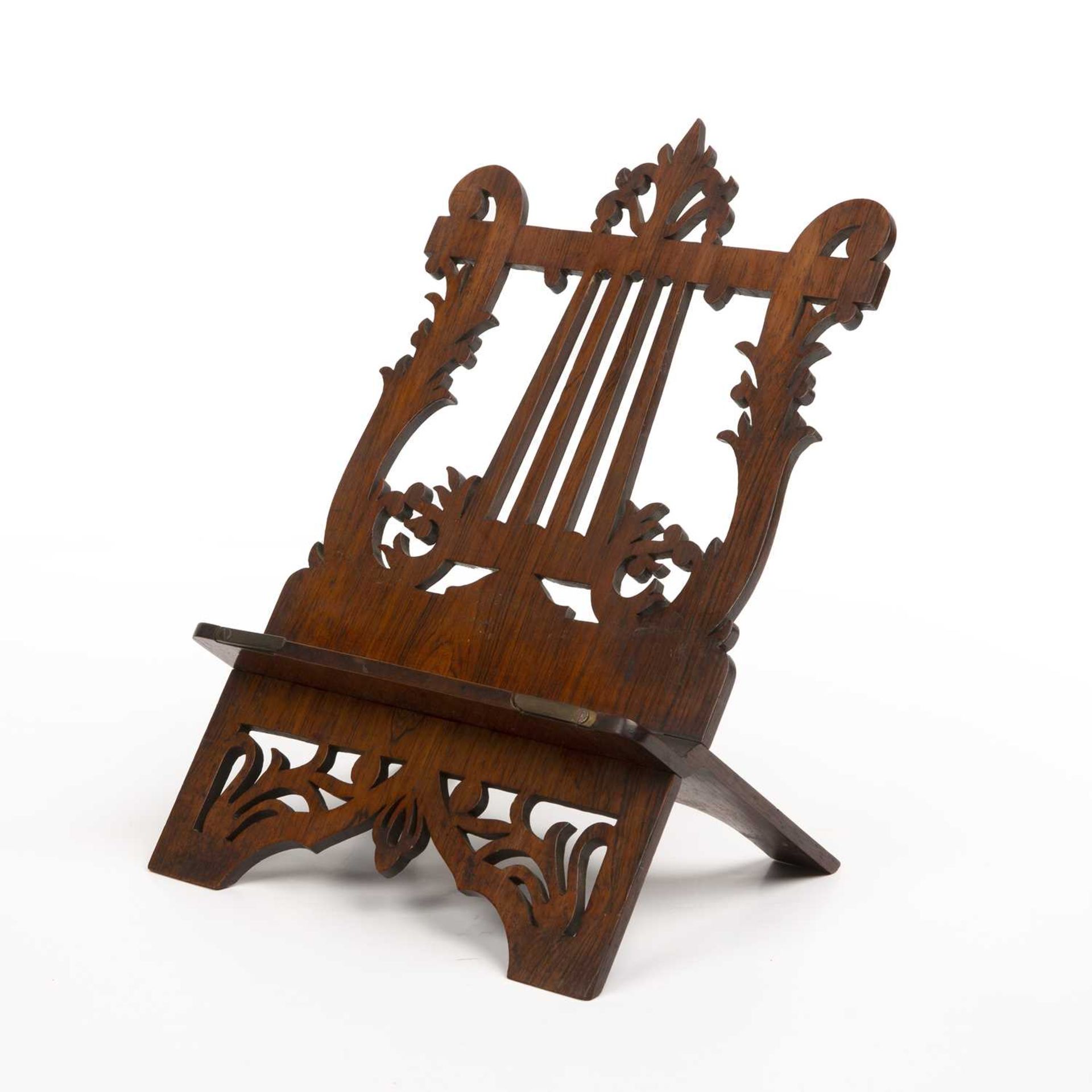 A 19th century rosewood table top music stand, of hinged form with fret pierced lyre shaped back,