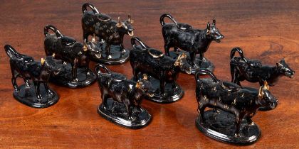 A herd of eight black glazed and parcel gilt North Country pottery cow creamers