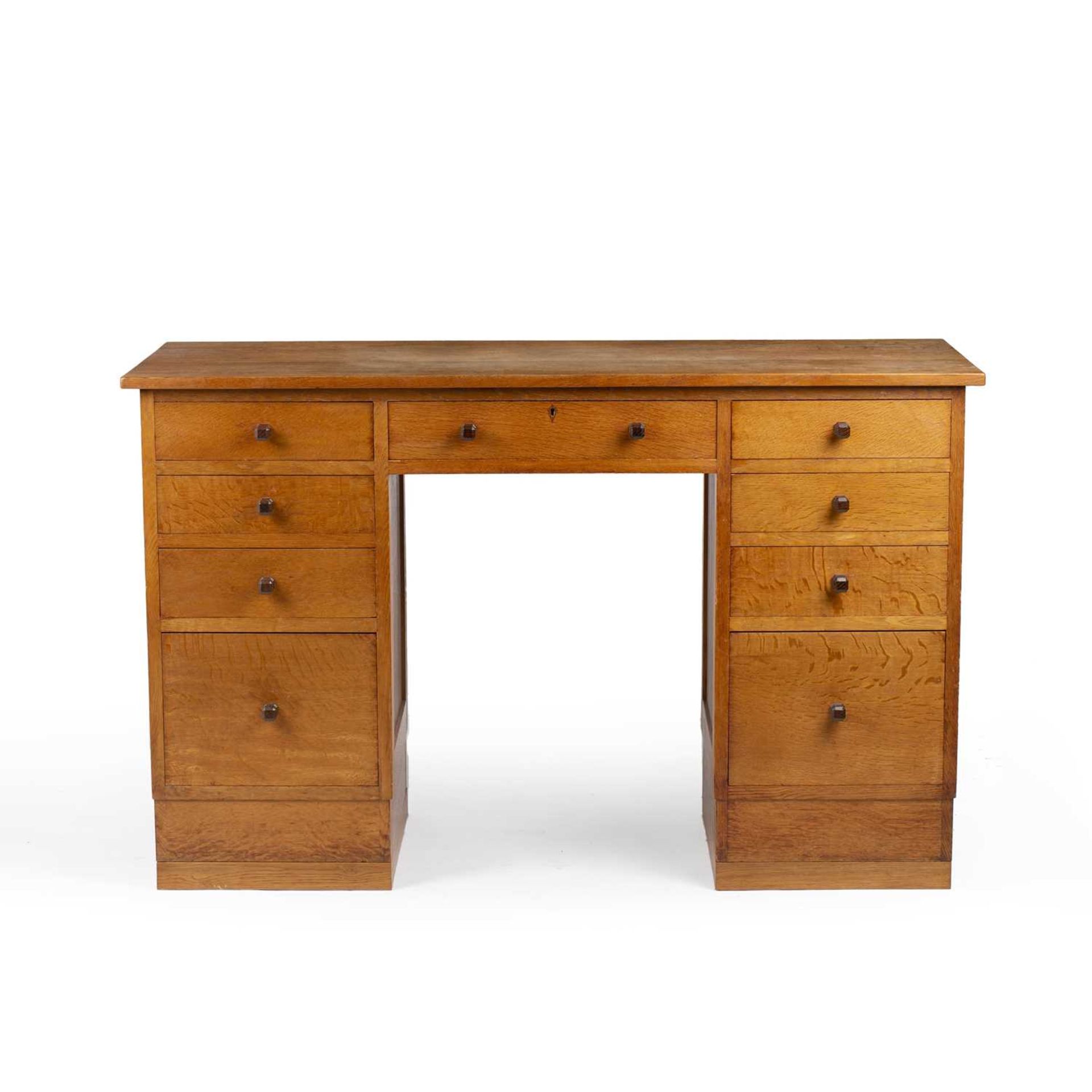 Gordon Russell (1892-1980) Desk, circa 1930 oak, with nine fitted drawers, each with carved