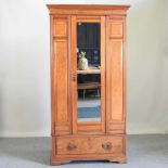 An Edwardian walnut single wardrobe