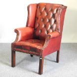 A red leather upholstered button back armchair