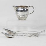 A silver cream jug and cutlery