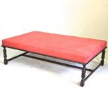 A large red upholstered coffee table