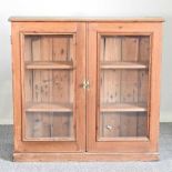 An antique pine glazed bookcase