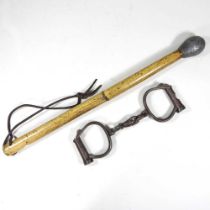 A pair of antique handcuffs and baton