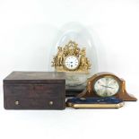 A gilt mantel clock under a glass dome