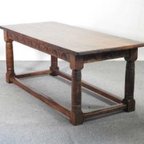 A handmade oak refectory dining table, on turned legs, with a carved frieze, on turned legs,