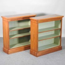 A pair of handmade walnut and crossbanded dwarf open bookcases, each with a painted interior, on a