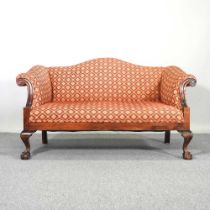 An early 20th century scroll end sofa, of Georgian style, upholstered in red, on cabriole legs,