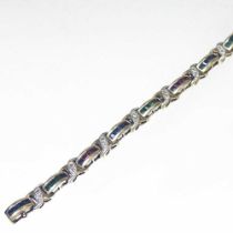 A 9 carat gold sapphire, diamond, ruby and emerald flexible link bracelet, set with a row of