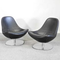 A pair of contemporary black upholstered swivel chairs, on chrome bases