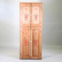 A pine and painted cupboard, decorated with urns and fitted with shelves 70w x 32d x 177h cm