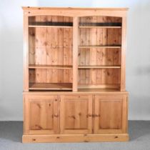 A large pine bookcase, with open shelves and cupboards below 158w x 46d x 200h cm