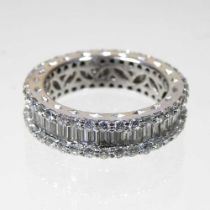 An 18 carat white gold diamond full hoop eternity ring, set with a frieze of baguette cut