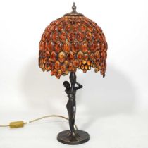 A Tiffany style figural table lamp, with an amber coloured glass shade, 56cm high overall