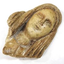 A carved stone fragment, carved as a head, possible Medieval, 22cm high