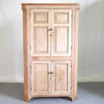 A 19th century pine standing corner cabinet, fitted with shelves 122w x 90d x 205 cm