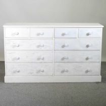 A white painted pine chest, containing a double row of drawers, on a plinth base 164w x 43d x 95h