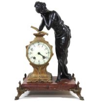 An early 20th century French figural mantel clock, surmounted by a young lady, on a red marble base,