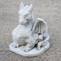 A cast stone model of a seated dragon, 56cm high