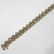 A 14 carat gold diamond line bracelet, set with a row of thirty-five champagne diamonds,