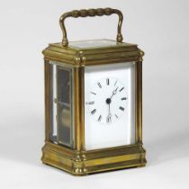 An early 20th century brass cased carriage clock, with engine turned decoration, having a white