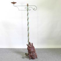 A painted iron candlestand, 158cm high, together with an African carved wooden mask (2)