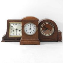 A 1920's oak cased mantel clock, 25cm high, together with two others smaller (3)