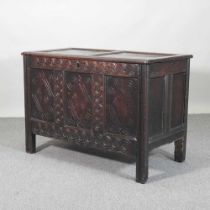 An 18th century panelled oak coffer, with a hinged lid and carved decoration 113w x 57d x 78h cm