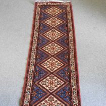 A Persian runner, with seven central medallions, on a blue ground, 367 x 76cm