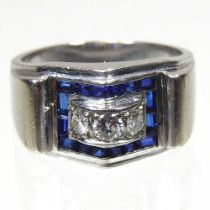 An Art Deco style 14 carat white gold, diamond and sapphire ring, set with three central diamonds,